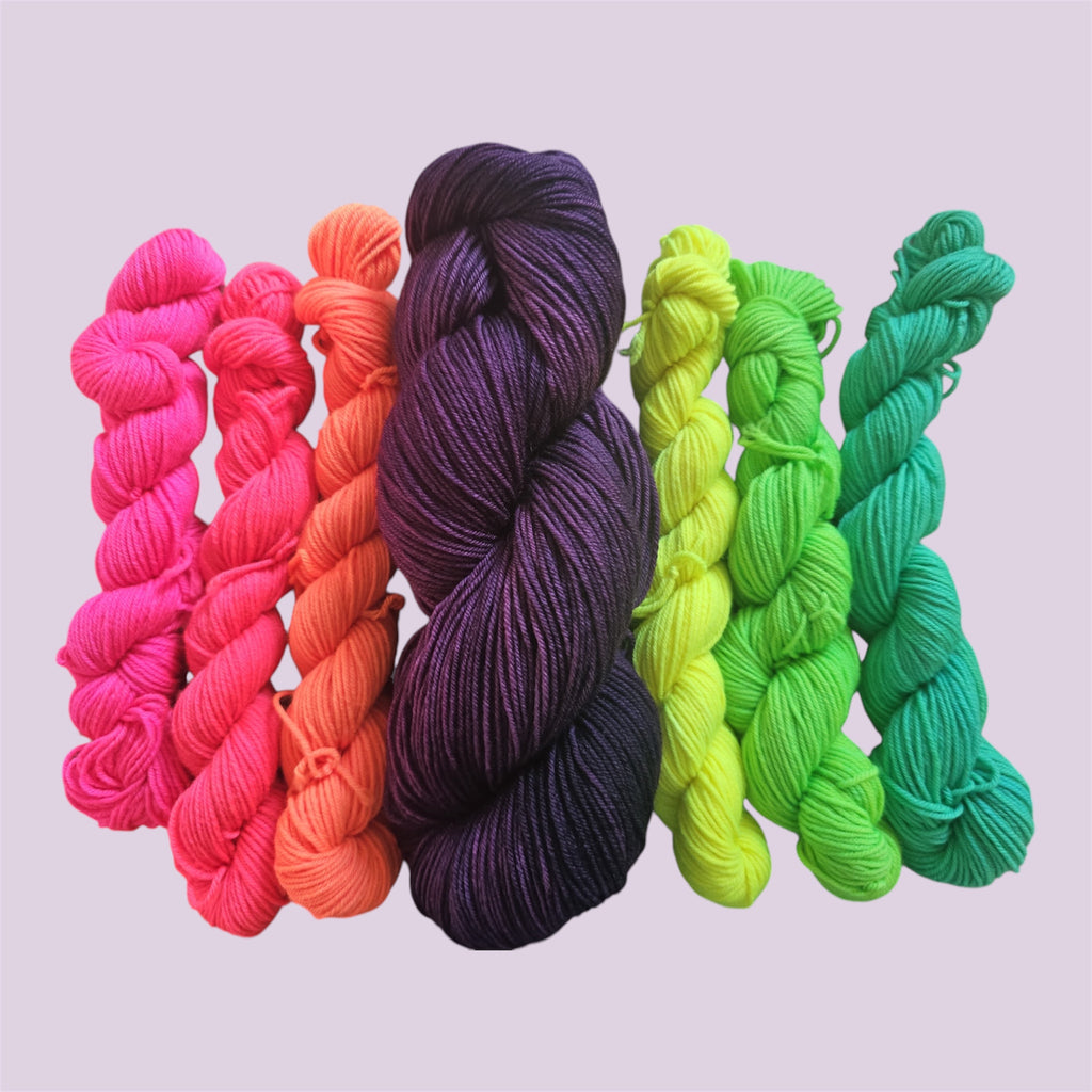 Sweet Spell hand-dyed sock yarn set with one deep purple 100g skein and six neon 20g mini skeins