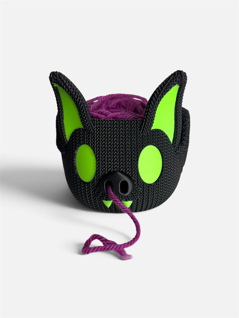 Barry the Bat Yarn Bowl in black with neon green eyes and ears, holding a purple 100g yarn ball